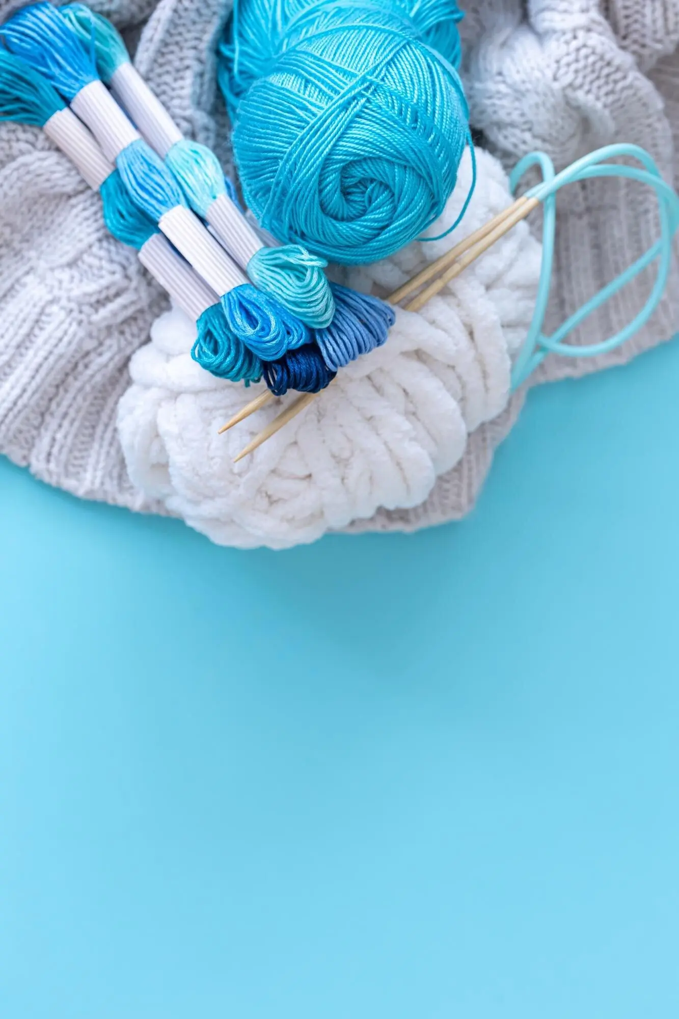 Fäden in verschiedenen Farben auf blauem Hintergrund.