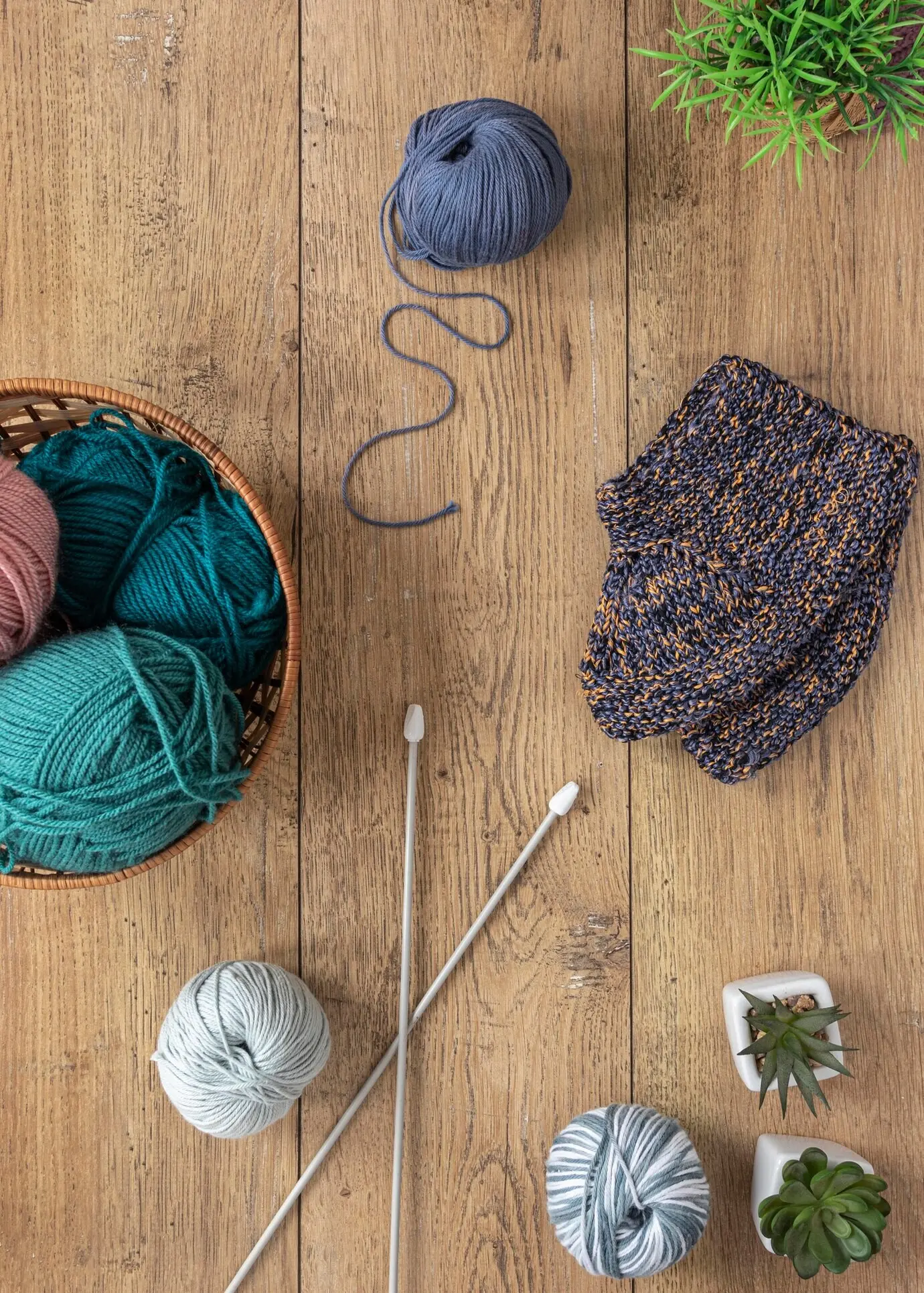 Wolle und Stricknadeln in einem Korb